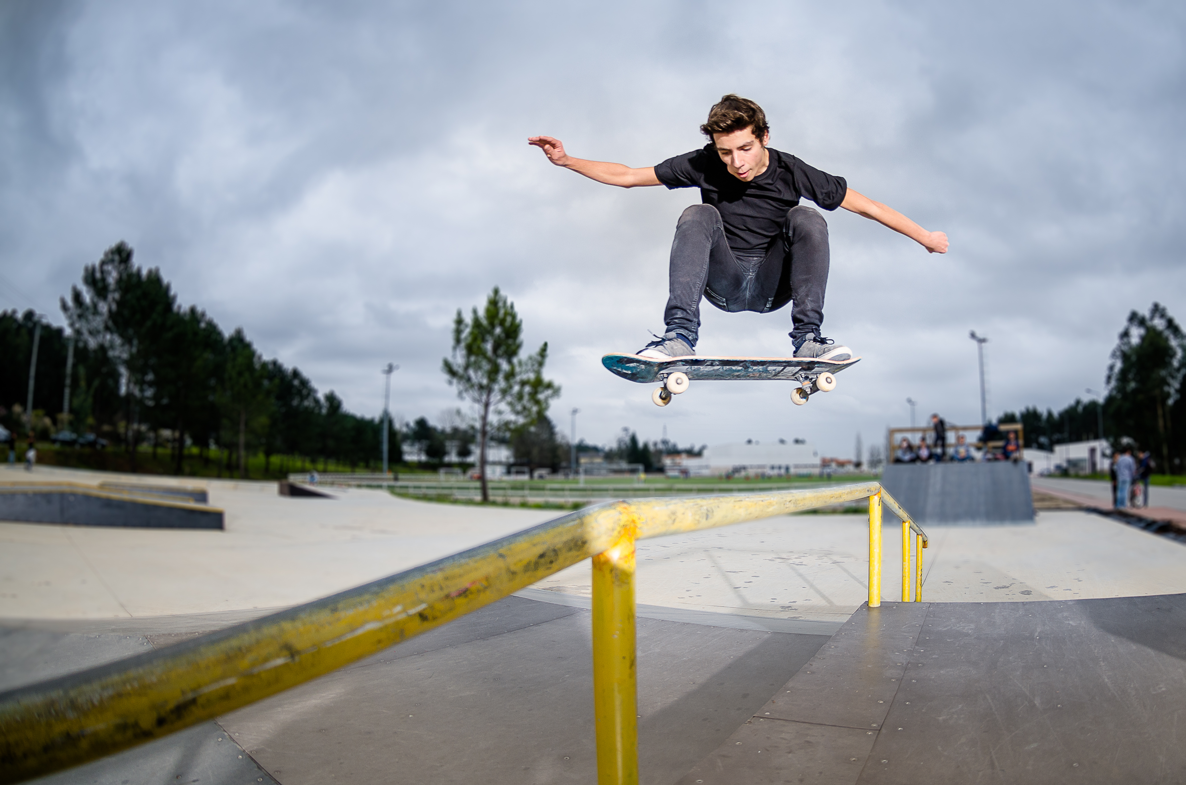 Jongen springt met  skateboard op ballustrade