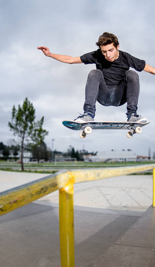 Jongen springt met skateboard op ballustrade
