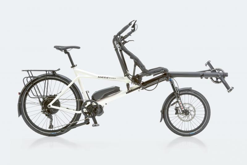 G-fiets waarbij de bestuurder achteraan zit en de G-sporter vooraan in de ligfiets kan meetrappen met de armen.