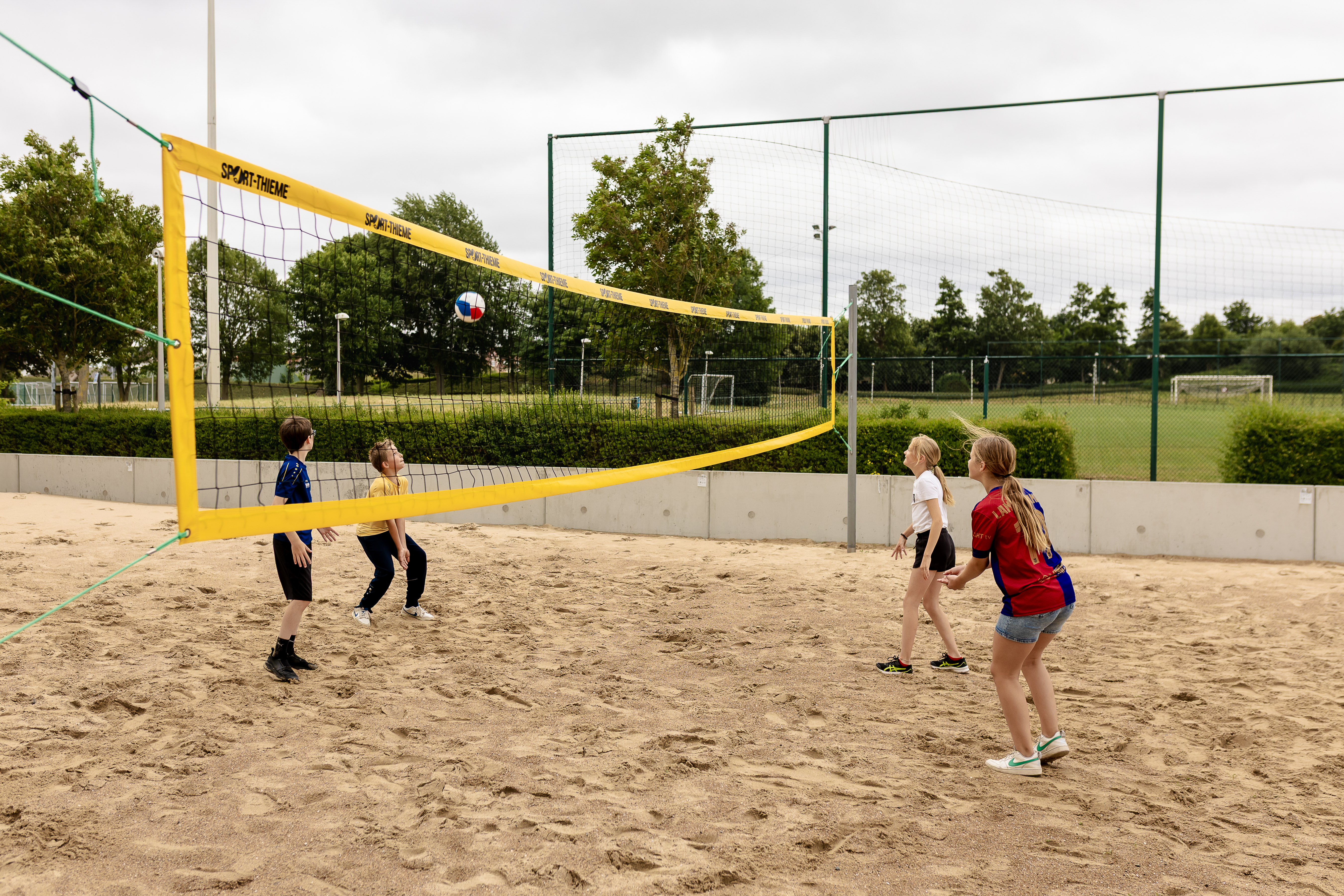 kinderen spelen 2-2 beachvolleybal