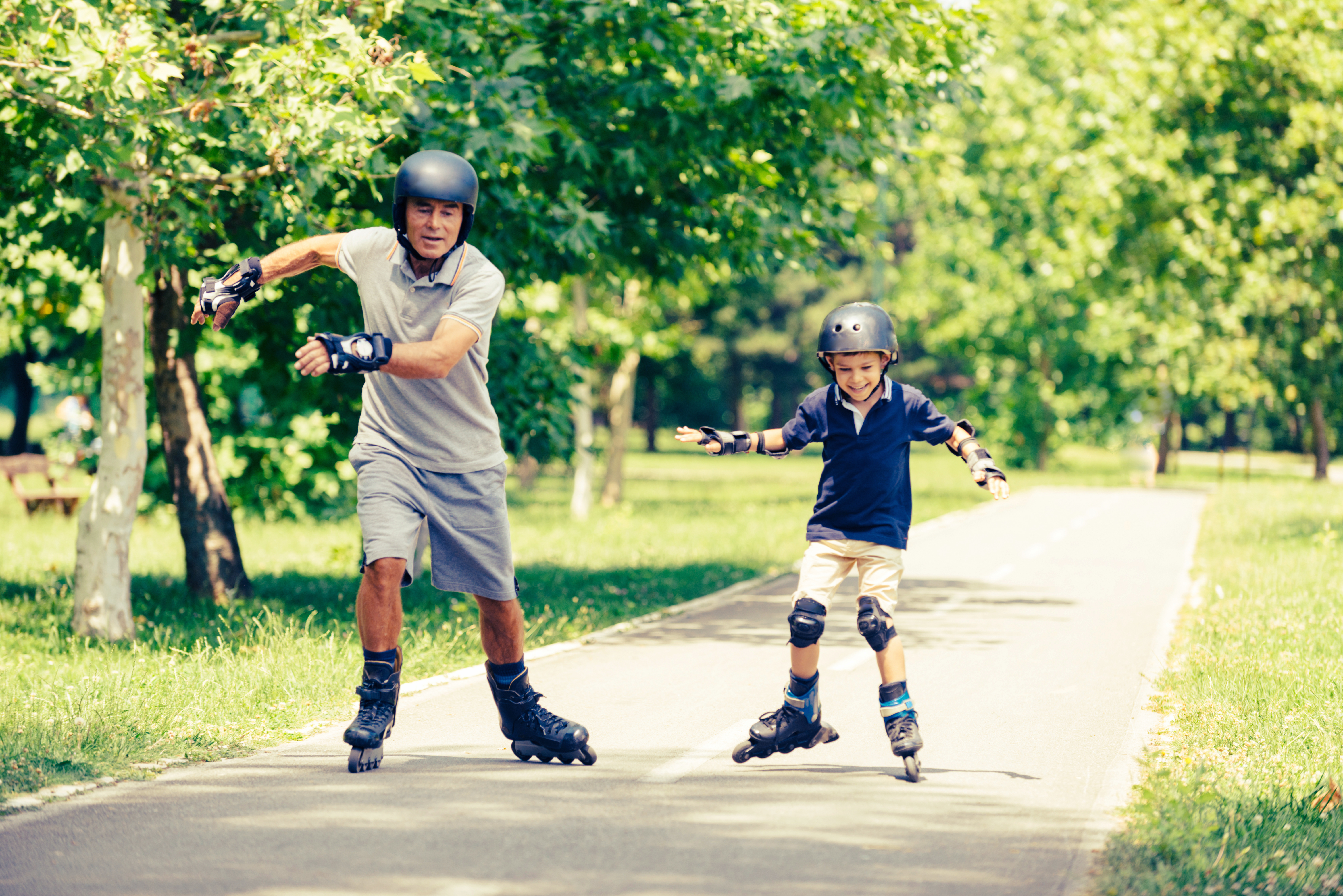 Vader en zoon rolschaatsen in park