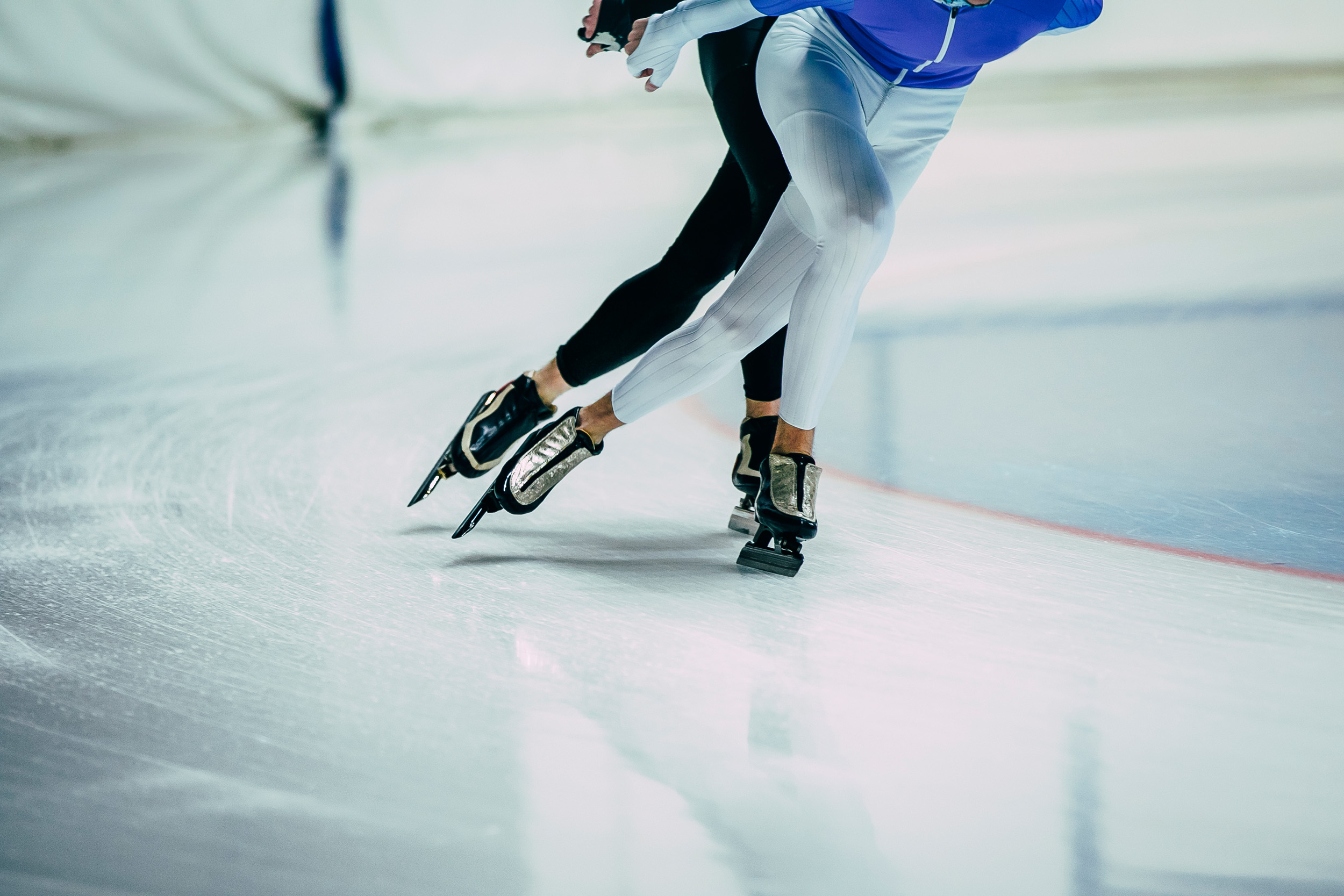 Benen van twee schaatsers die aan het schaatsen zijn indoor 