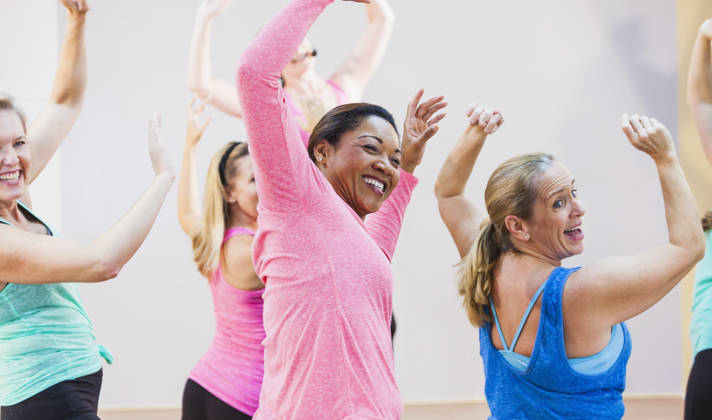 Multi-culturele groep dames dansen met handen in de lucht