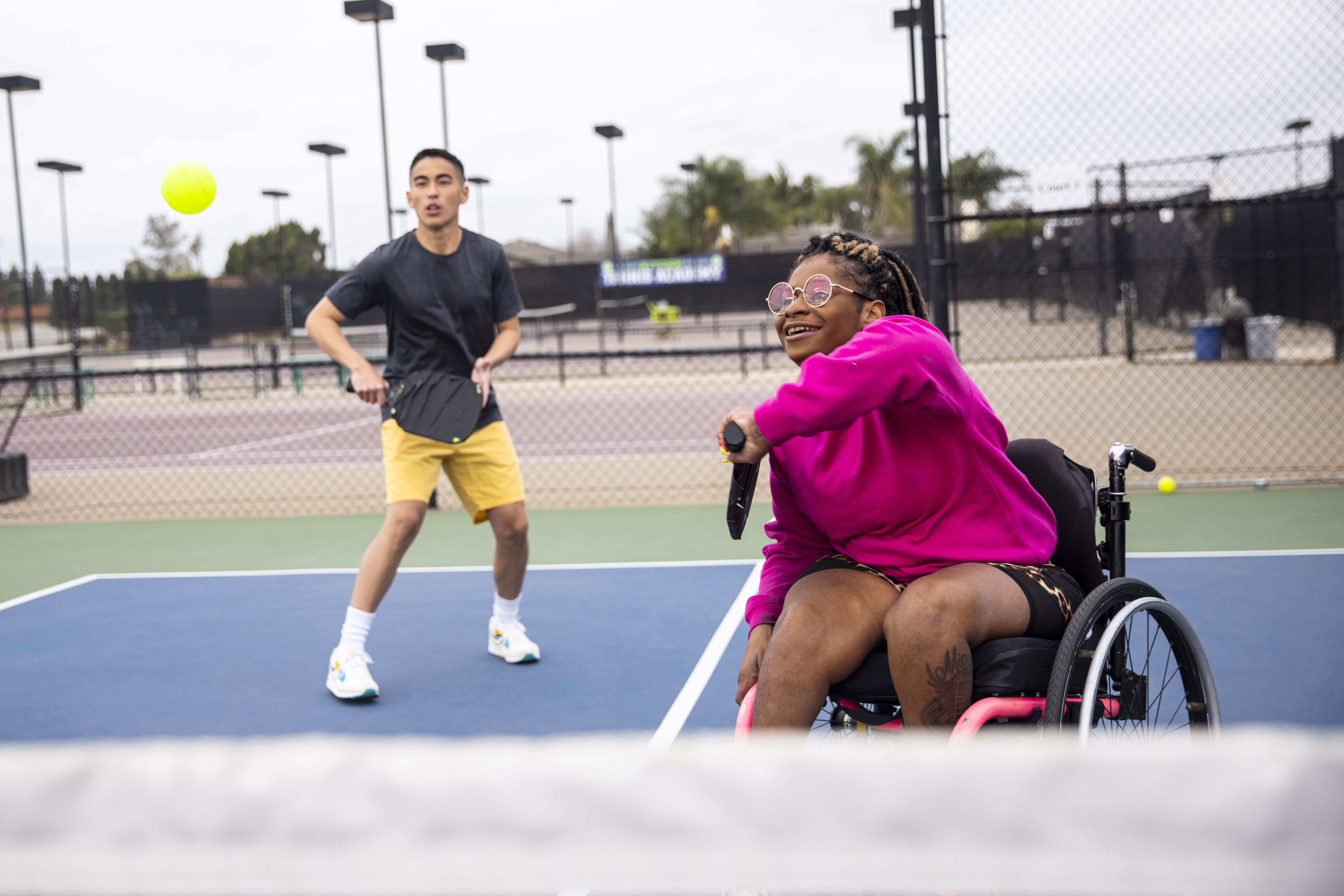 Meisje in rolstoel speelt tennis dubbel