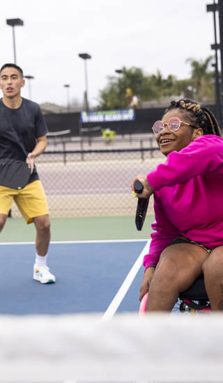 Meisje in rolstoel speelt tennis dubbel