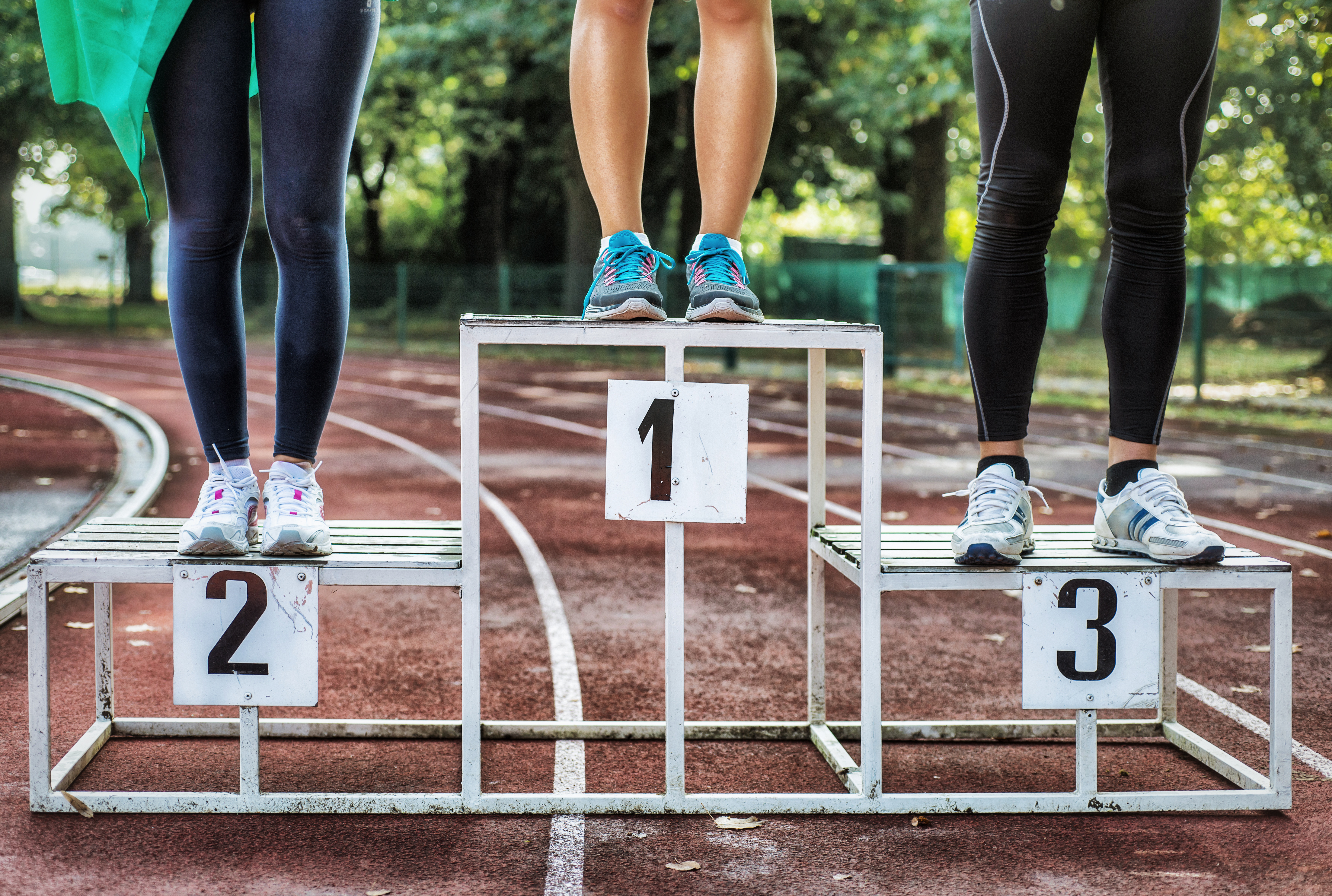 Drie paar benen van atleten op podium