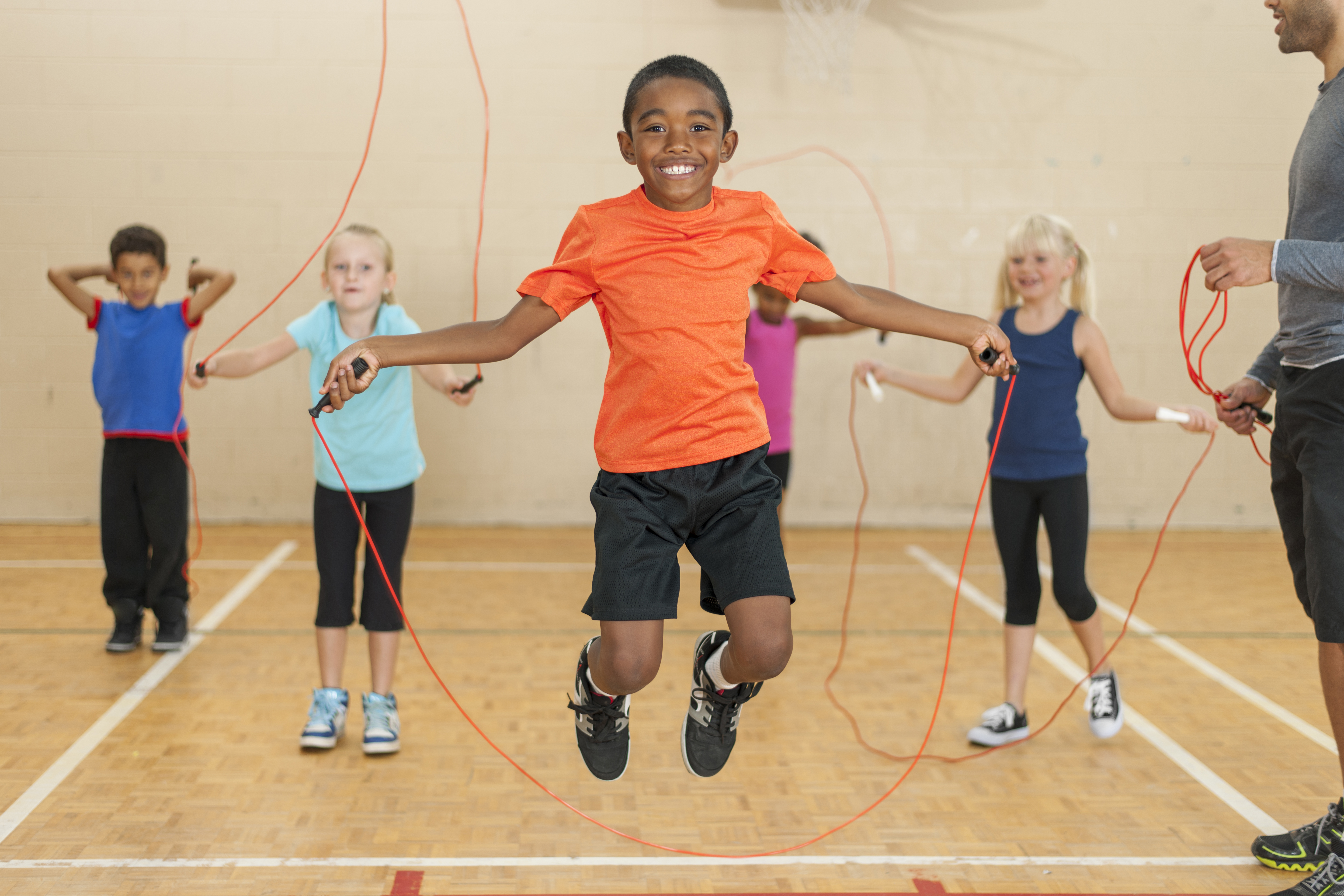 Verschillende kindjes met springtouw samen met coach