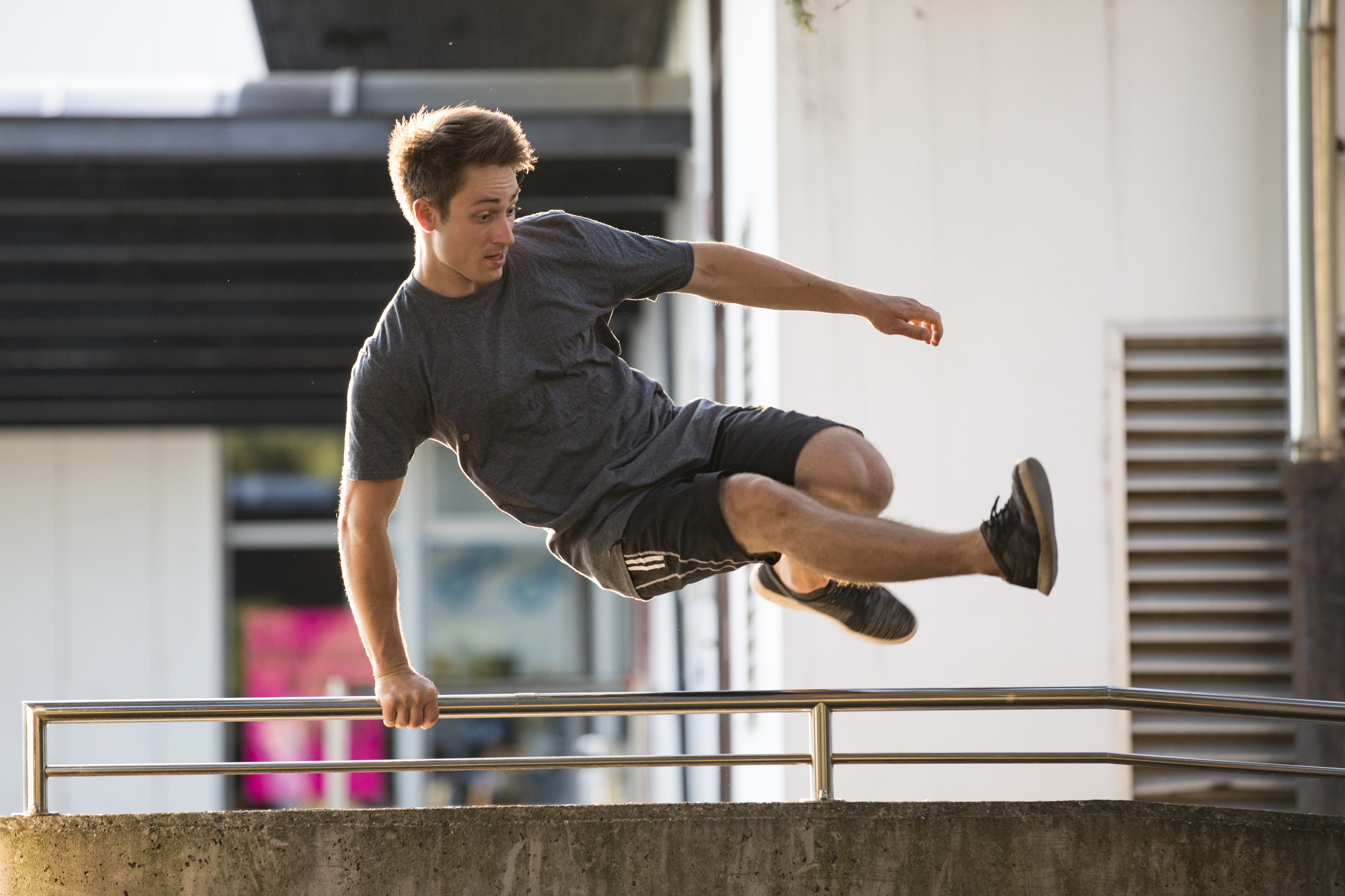 Jonge man springt over omheining