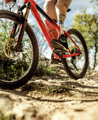 man with a prosthetic leg ride a mountain bike on a hill