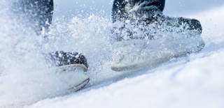 Two breaking ice skates with flying snow