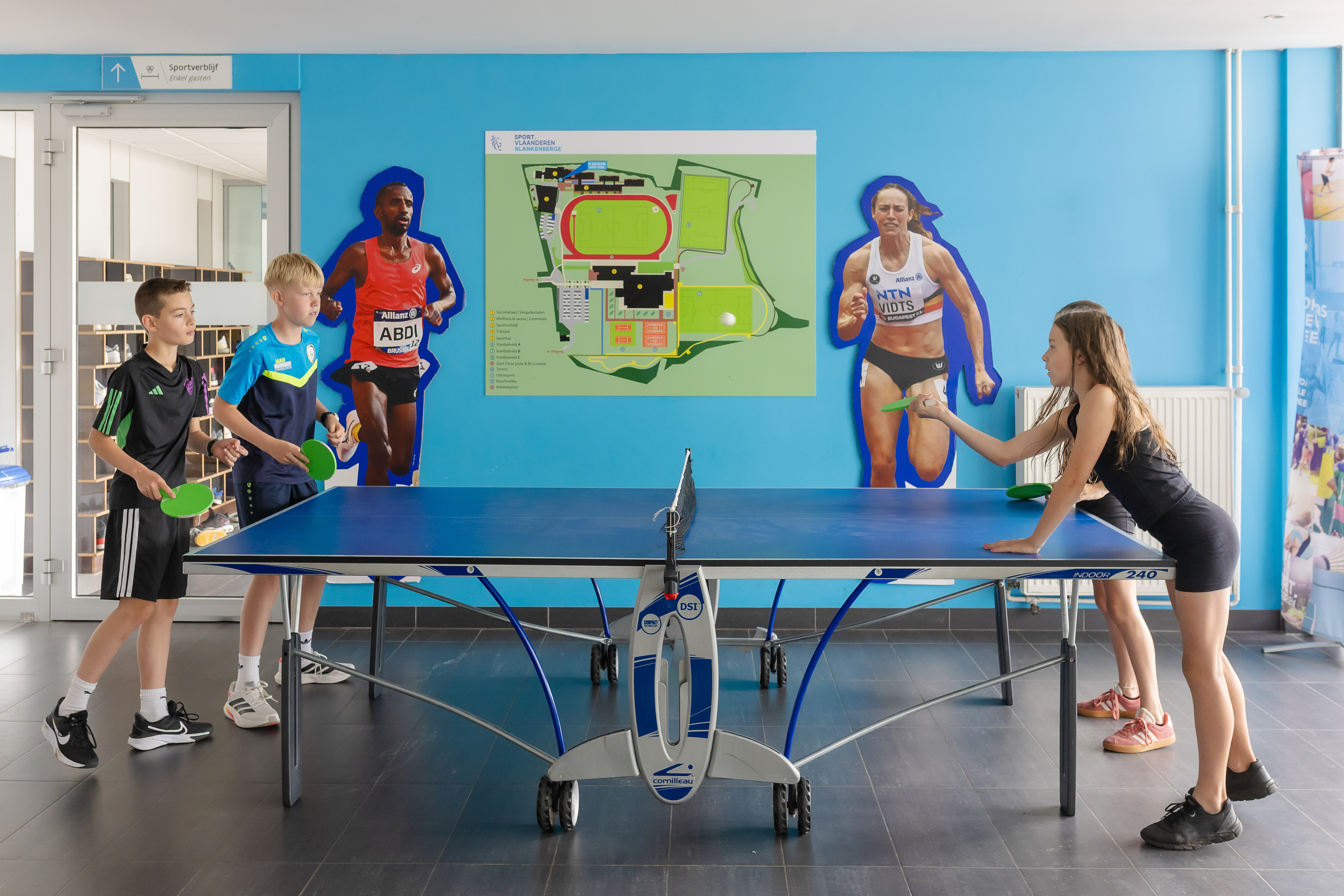 4 kinderen spelen tafeltennis in inkom sportverblijf