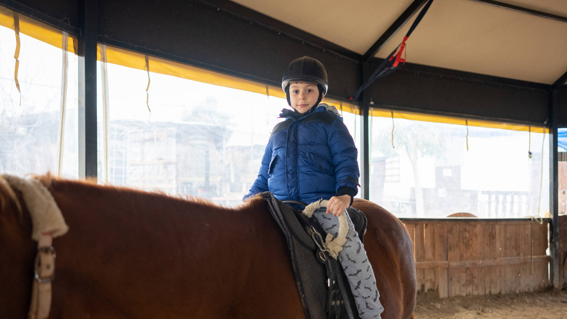 Little boy riding training horse