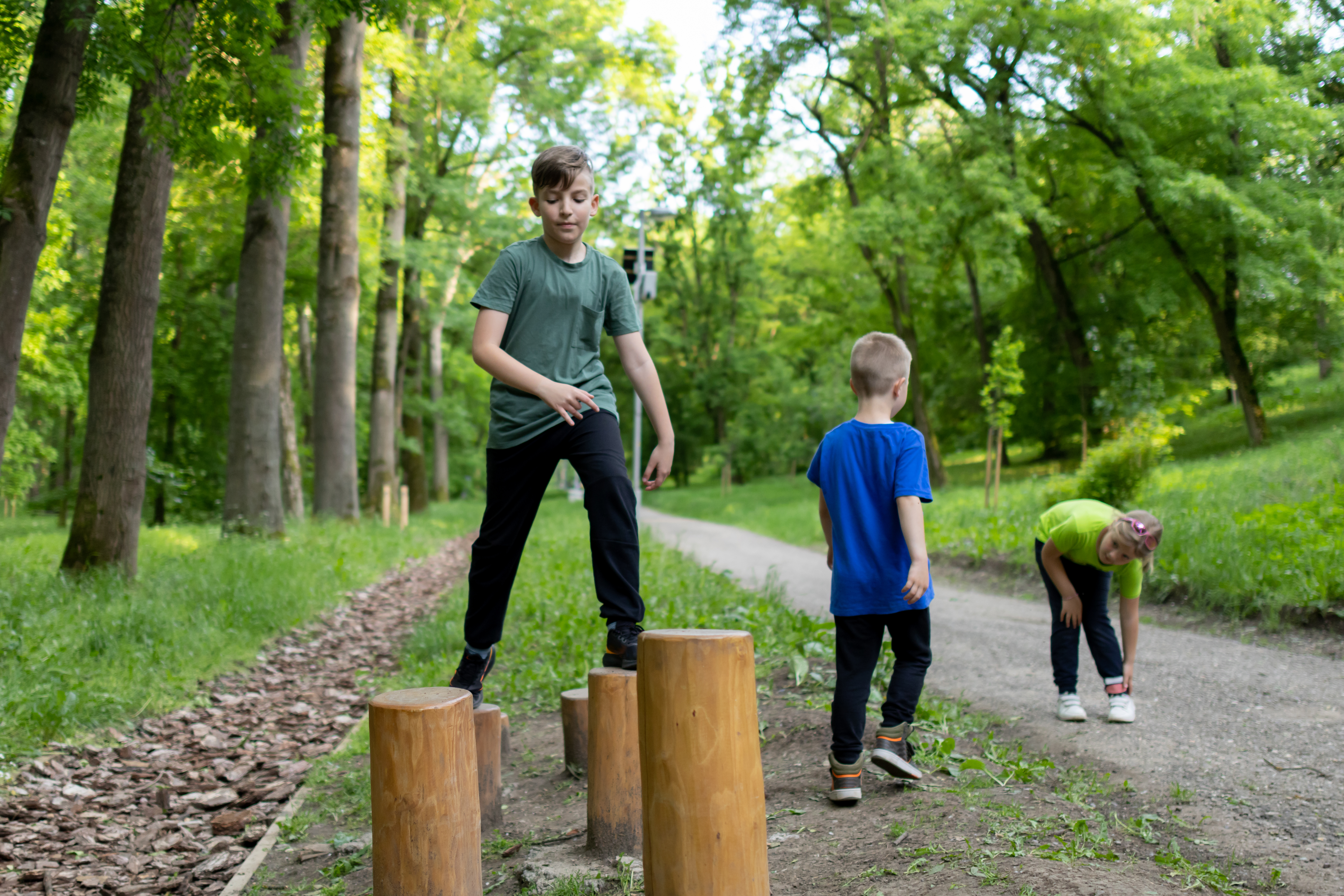 Children are playing at the public park on outdoor exercise equipment. A family having fun. Healthy physical activities simple concept. Active children, fit sporty children exercising.