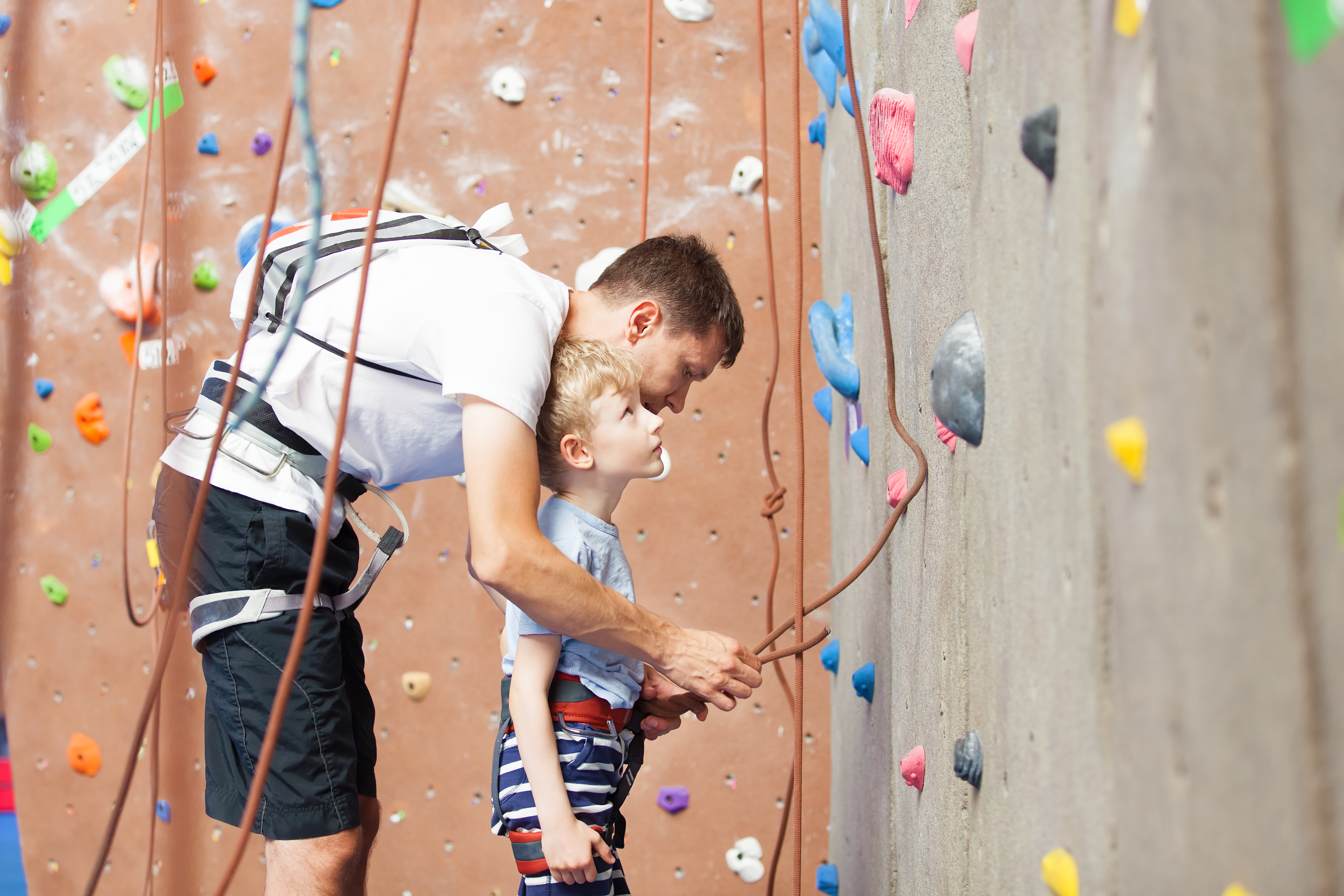 Kleuter met coach op klimmuur