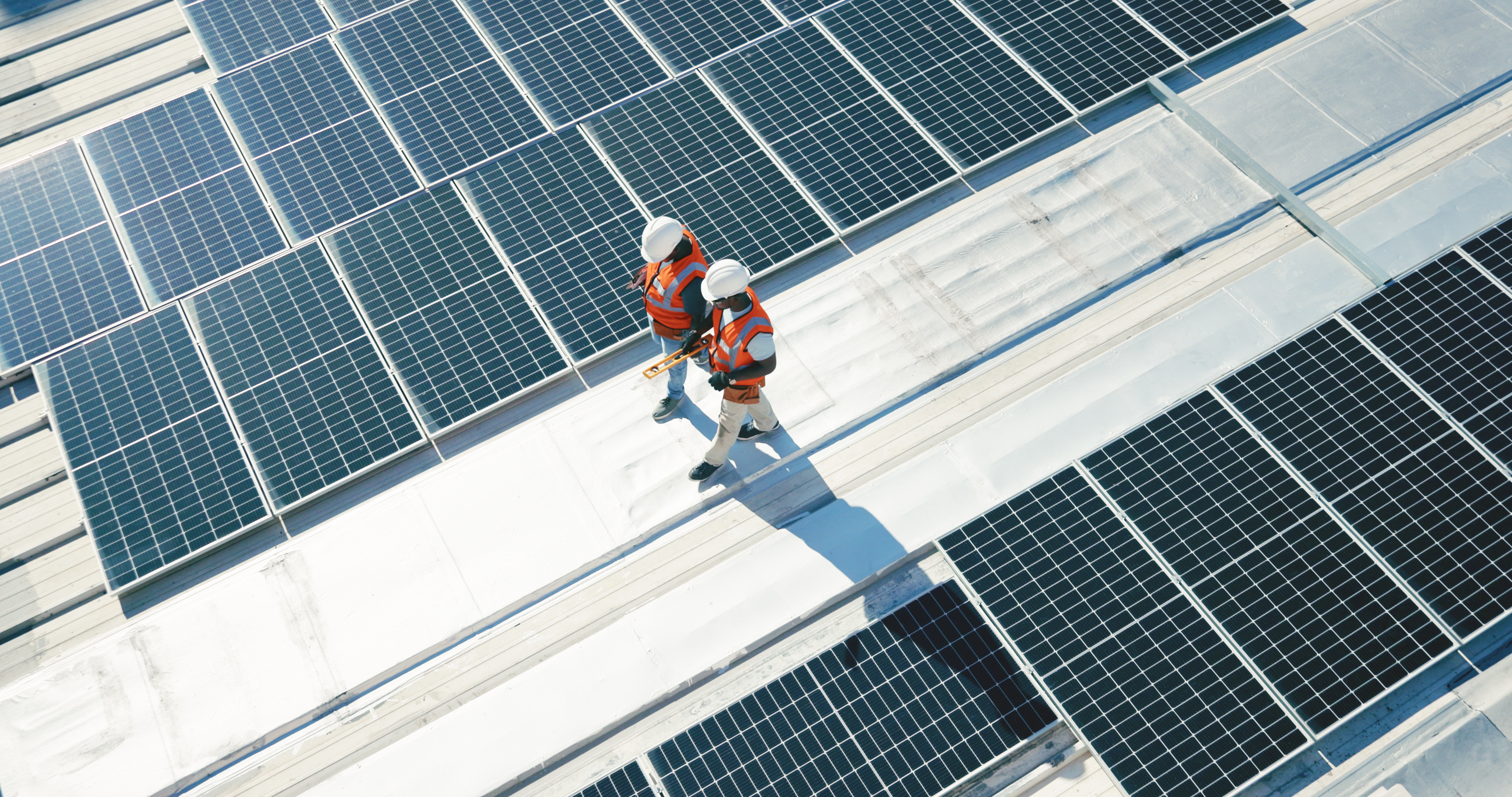 Renewable energy, solar panels and team walking on roof planning for inspection at sustainable business. Engineering, sustainability and photovoltaic power on rooftop, men in electricity maintenance.