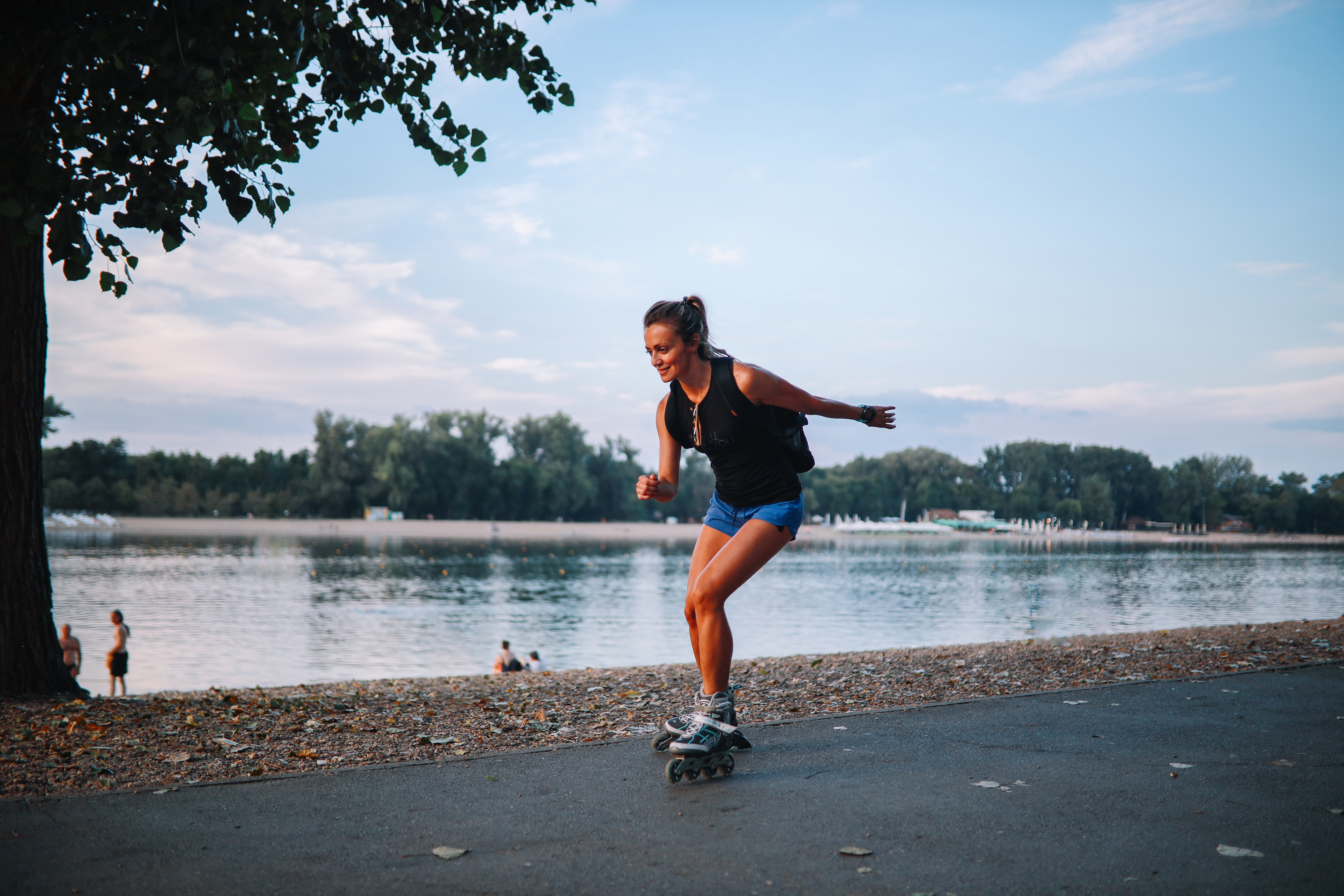 Meisje dat aan het rolschaatsen is op een pad langs het water 