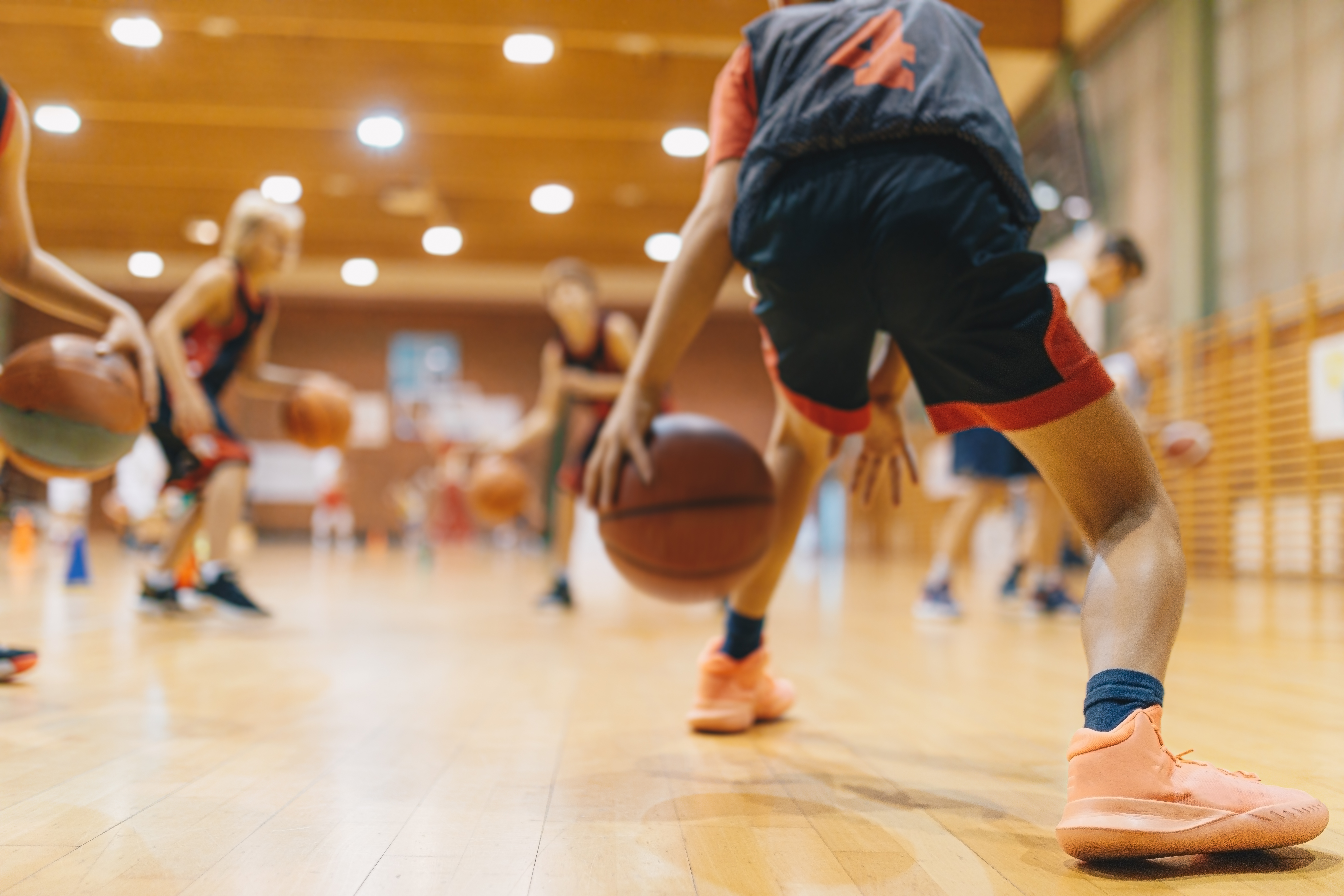 Jonge basketters tijdens training dribbelen met de bal 