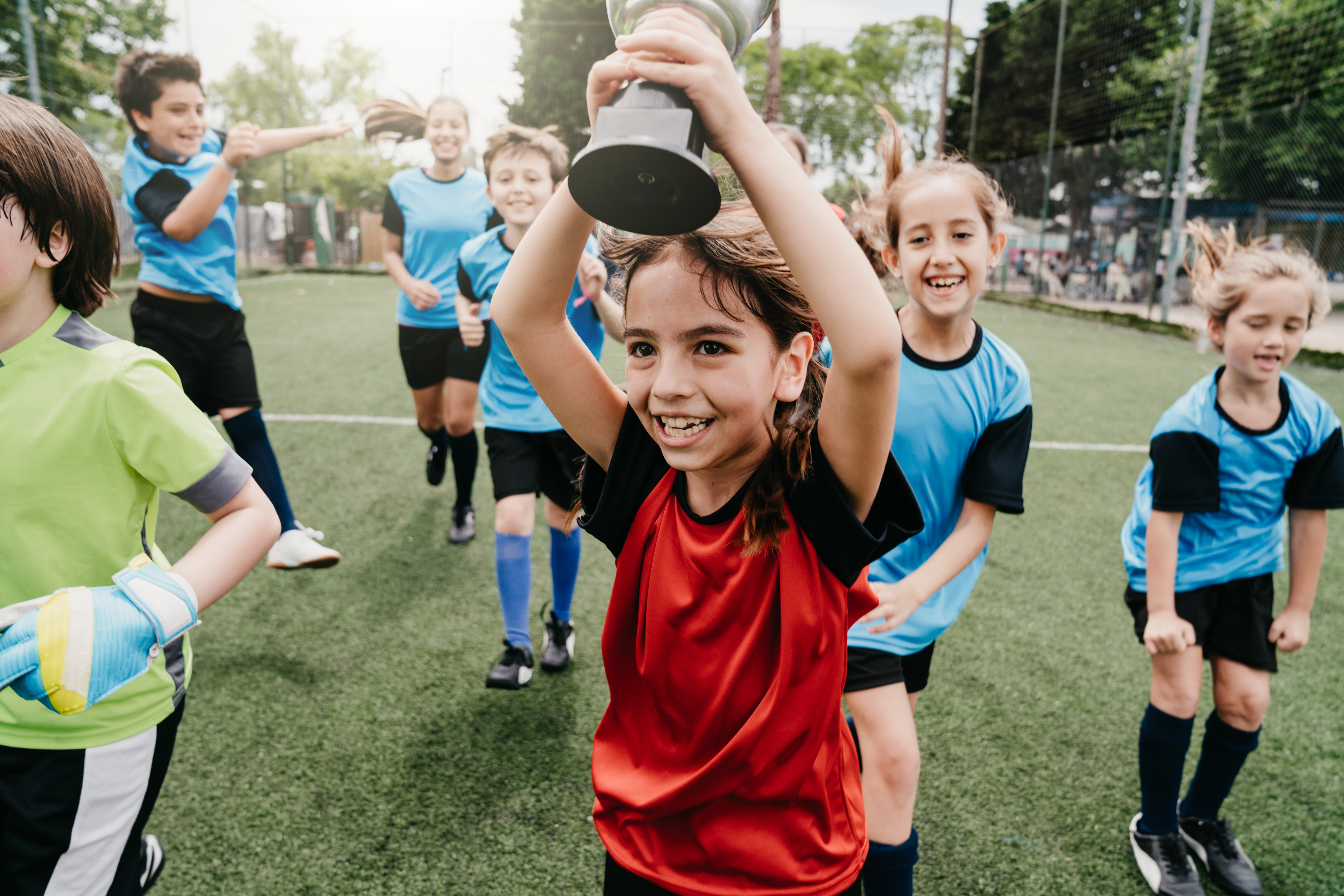 Groepje kinderen viert overwinning met beker